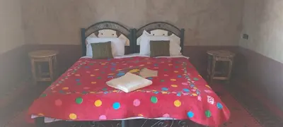 a bedroom with a red bed with polka dots at Mhamid Regency Camp in Mhamid