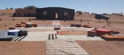 a building in the middle of a desert with a building at Mhamid Regency Camp in Mhamid