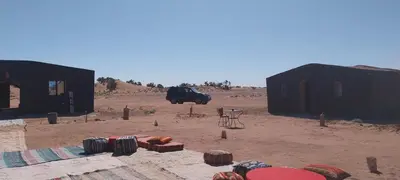 a group of huts in the middle of a desert at Mhamid Regency Camp in Mhamid