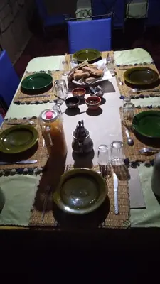 a table with green plates and glasses on it at Mhamid Regency Camp in Mhamid