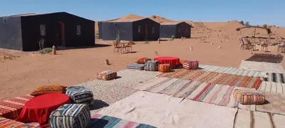 a group of tents in the middle of the desert at Mhamid Regency Camp in Mhamid