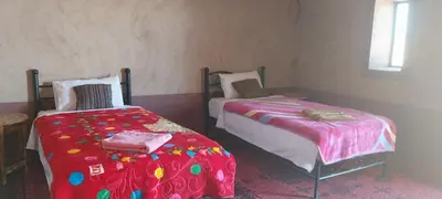a room with two beds and a window at Mhamid Regency Camp in Mhamid