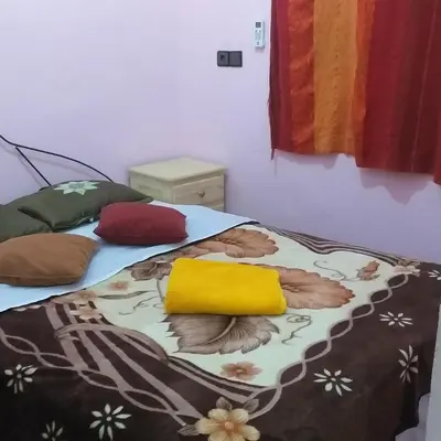 a bedroom with two beds with colorful pillows on them at Merzouga Quiet apart &camels trecking in Merzouga