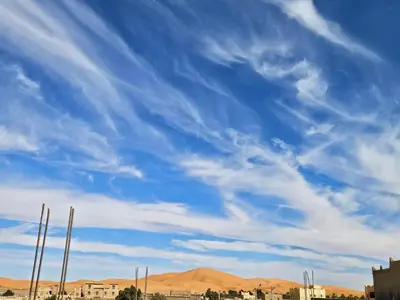a blue sky with wispy clouds in the sky at Merzouga Quiet apart &camels trecking in Merzouga