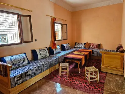 a living room with a couch and a table at Merzouga Quiet apart &camels trecking in Merzouga