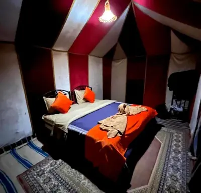 a bedroom with a bed in a tent at Bedouin Desert Camp in Merzouga