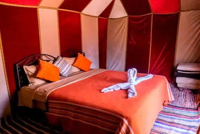 a bedroom with a bed in a tent at Bedouin Desert Camp in Merzouga