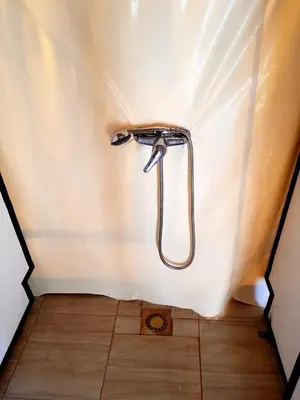 a shower in the corner of a room at Bedouin Desert Camp in Merzouga