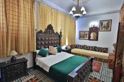 a bedroom with two beds and a chandelier at Spacious Apartment in Fès with Private Pool, 150 sqm in Fès