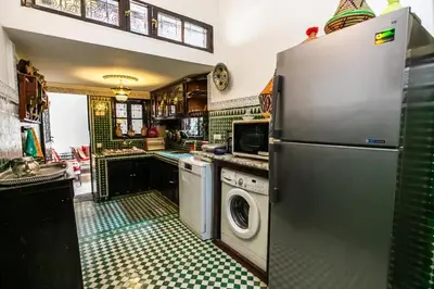a kitchen with a refrigerator and a washing machine at Spacious Apartment in Fès with Private Pool, 150 sqm in Fès