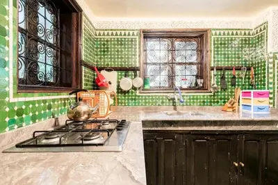 a kitchen with a stove and a green tiled wall at Spacious Apartment in Fès with Private Pool, 150 sqm in Fès