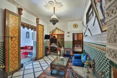 a living room with a blue couch and a table at Spacious Apartment in Fès with Private Pool, 150 sqm in Fès