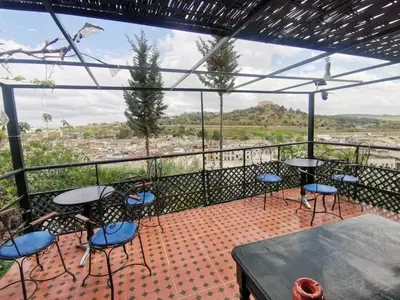 a balcony with tables and chairs and a view at Cosy Apartment in Fes El Bali, 25 m², Private Garden in Fès