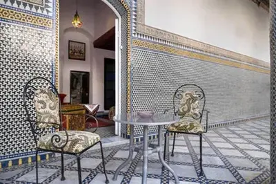a table and two chairs in a room with a wall at Cosy Apartment in Fes El Bali, 25 m², Private Garden in Fès