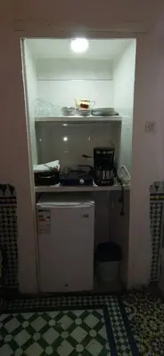 a small kitchen with a small refrigerator in a room at Cosy Apartment in Fes El Bali, 25 m², Private Garden in Fès