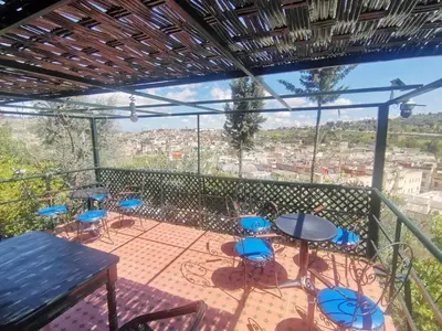 a balcony with tables and chairs and a view of a city at Cosy Apartment in Fes El Bali, 25 m², Private Garden in Fès