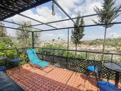 a balcony with chairs and tables and a view of the city at Cosy Apartment in Fes El Bali, 25 m², Private Garden in Fès
