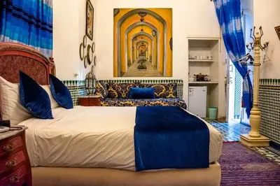 a bedroom with a large bed with blue pillows at Cosy Apartment in Fes El Bali, 25 m², Private Garden in Fès