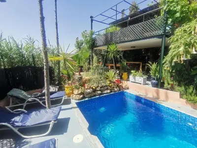 a swimming pool in a backyard with chairs and plants at Cosy Apartment in Fes El Bali, 25 m², Private Garden in Fès