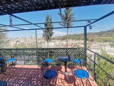a balcony with chairs and tables and a view at Charming Apartment in Fès - 30 m² + View in Fès