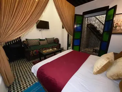 a bedroom with a large bed and a couch at Charming Apartment in Fès - 30 m² + View in Fès