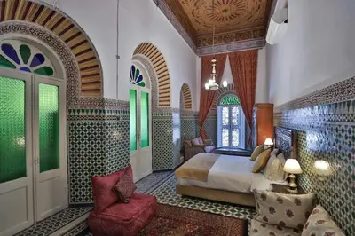 a bedroom with a bed and a chair in a room at Charming Apartment in Fes El Bali, 150m² with Garden in Fès
