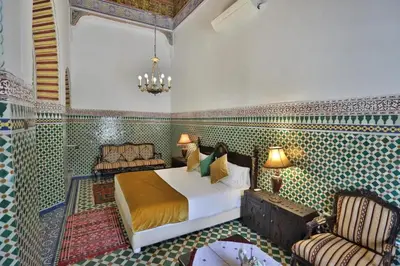 a bedroom with a bed and a chair in a room at Charming Apartment in Fes El Bali, 150m² with Garden in Fès