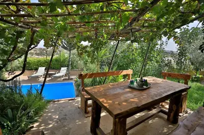 a wooden table and chairs under a pergola at Charming Apartment in Fes El Bali, 150m² with Garden in Fès
