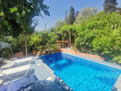 a swimming pool in a yard with chairs and trees at Charming Apartment in Fes El Bali, 150m² with Garden in Fès