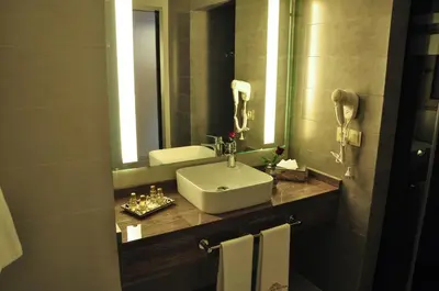 a bathroom with a sink and a mirror at Hôtel Atlas Saiss Fès in Fès