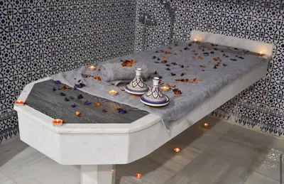 a white bed with flowers on it in a room at Hôtel Atlas Saiss Fès in Fès