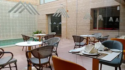 a restaurant with tables and chairs and a pool at Hôtel Atlas Saiss Fès in Fès