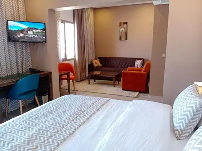 a hotel room with a bed and a couch at Hôtel Atlas Saiss Fès in Fès