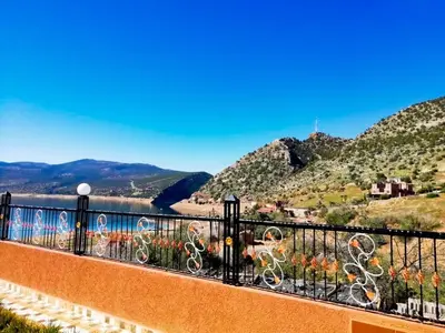 a balcony with a view of a river and mountains at Scenic Lakeview House Near 5-Star Widian Hotel in Bine el Ouidane