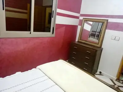 a bedroom with a bed and a mirror and a dresser at Scenic Lakeview House Near 5-Star Widian Hotel in Bine el Ouidane