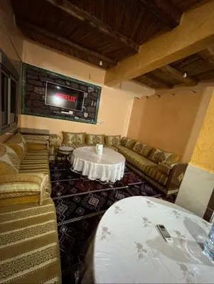 a room with couches and a table and a tv at Scenic Lakeview House Near 5-Star Widian Hotel in Bine el Ouidane