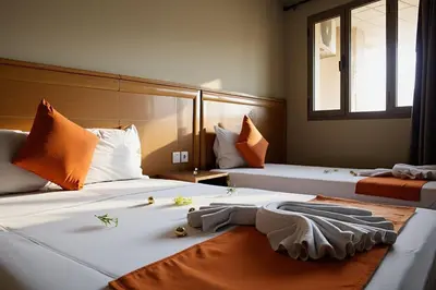 two beds in a hotel room with flowers on them at Hotel Golden Flora in Beni Mellal