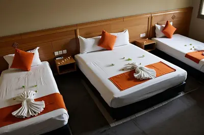 a room with two beds with orange and white pillows at Hotel Golden Flora in Beni Mellal