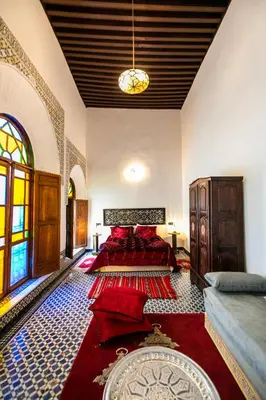a bedroom with a bed with red pillows on it at Palais Riad Chahd Luxury in Fès