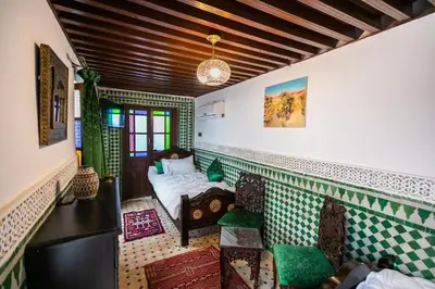 a living room with a bed and chairs in a room at Palais Riad Chahd Luxury in Fès