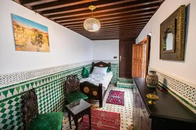 a room with green and white tiled walls and a bedroom at Palais Riad Chahd Luxury in Fès