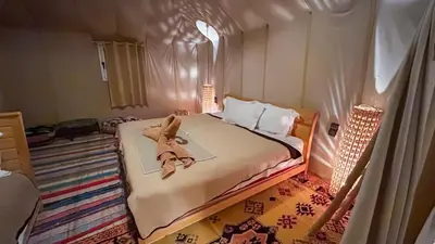 a bedroom with a bed with a teddy bear on it at Jardin Kotori Luxury Camp in Merzouga