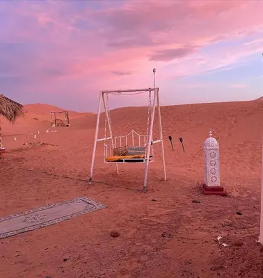 a swing in the middle of the desert at Merzouga Desert Luxury Camp in Merzouga