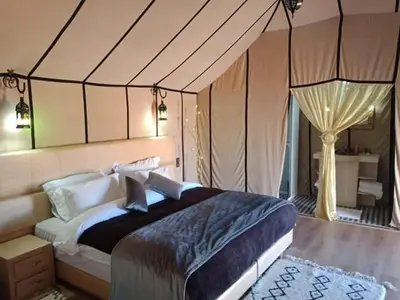 a bedroom with a large bed in a tent at Merzouga Desert Luxury Camp in Merzouga