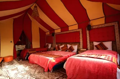 a bedroom with two beds in a circus tent at Merzouga Desert Luxury Camp in Merzouga