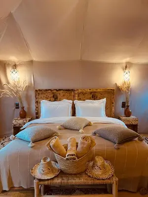 a bedroom with a large bed with baskets on it at Amskou Camp in Merzouga