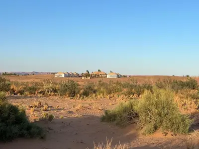 a view of a desert with houses in the distance at Amskou Camp in Merzouga
