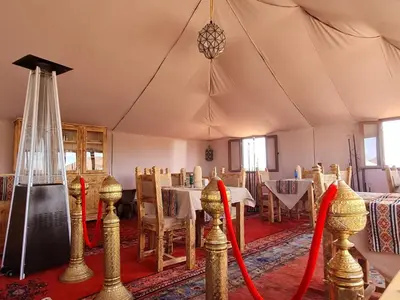 a dining room with a table with red bows at Amskou Camp in Merzouga
