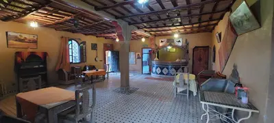 a room with tables and chairs in a building at Dar Tafouyte in Merzouga