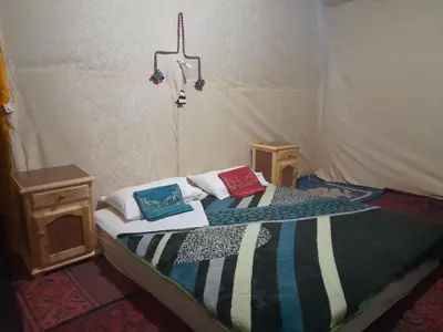 a bed in a tent with two pillows on it at RestCamp ErgChebbi in Merzouga